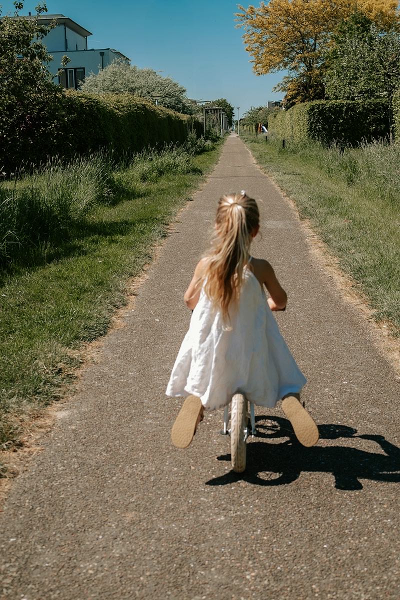 Girl cycling along a sunny path