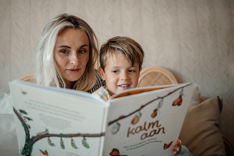 Nanny leest een prentenboek voor aan een jongen