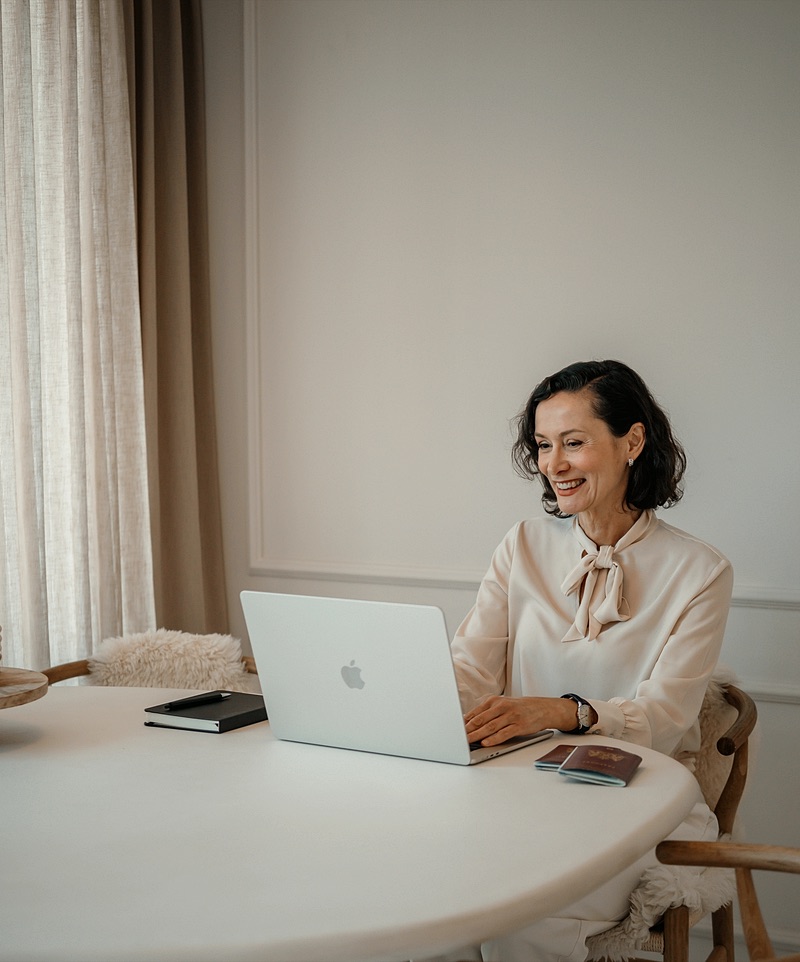 Vrouw werkt ontspannen achter haar laptop aan de eettafel